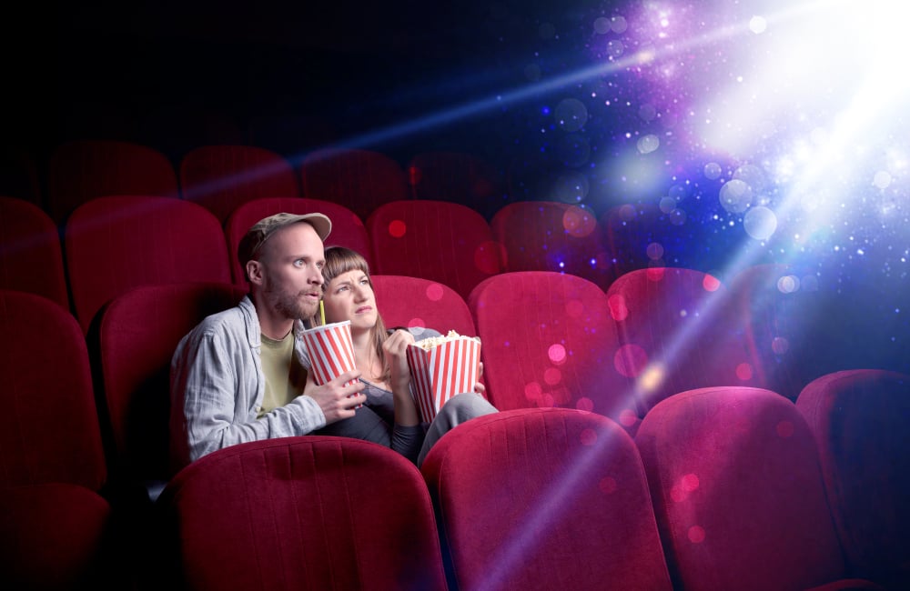 Romantic couple cuddling and watching the miraculous part of the film